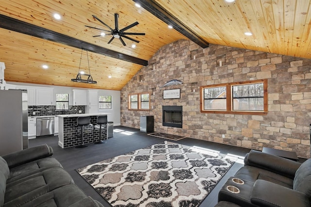living area featuring vaulted ceiling with beams, wooden ceiling, ceiling fan, and dark wood finished floors