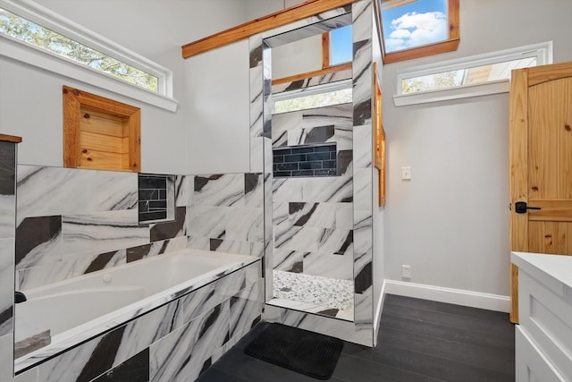 bathroom featuring a bath, baseboards, wood finished floors, and a walk in shower