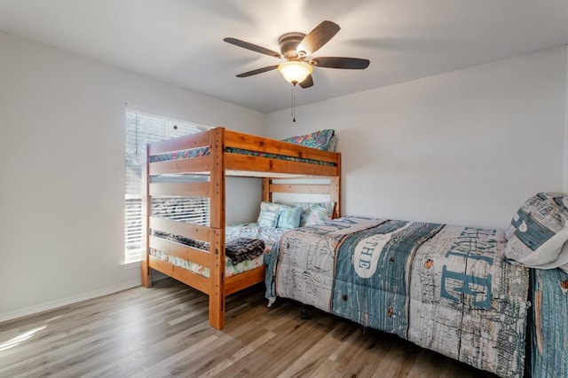 bedroom with ceiling fan, baseboards, and wood finished floors