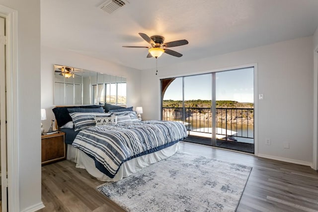 bedroom with access to exterior, visible vents, baseboards, and wood finished floors