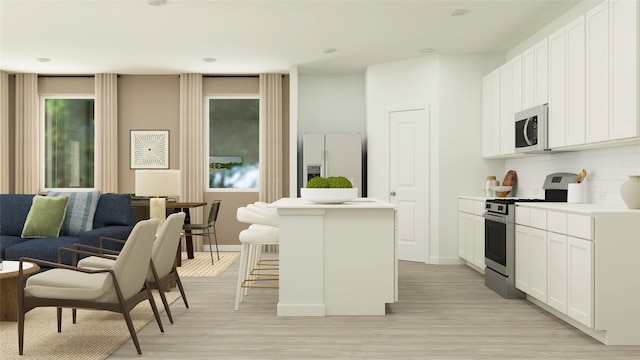 kitchen featuring a center island, white microwave, stainless steel range oven, fridge with ice dispenser, and a kitchen breakfast bar