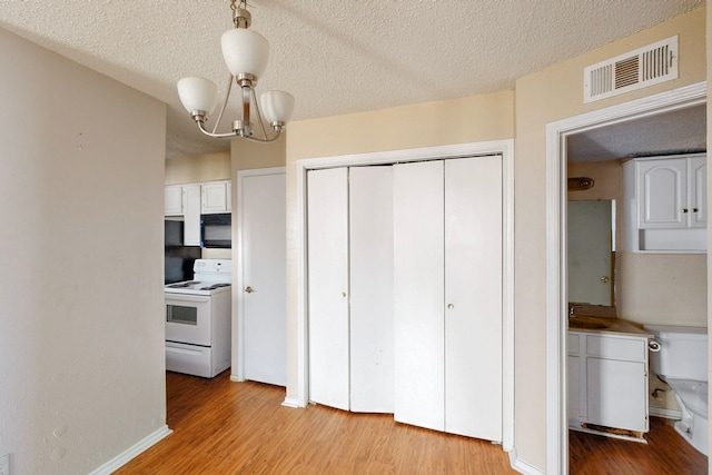 kitchen with white electric stove, visible vents, a notable chandelier, and light wood finished floors