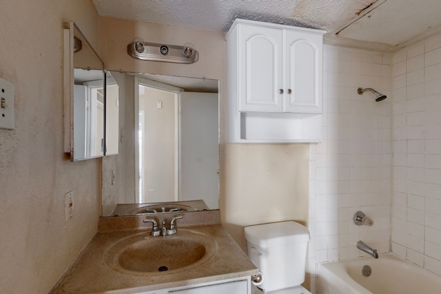 bathroom with vanity, toilet, washtub / shower combination, and a textured ceiling