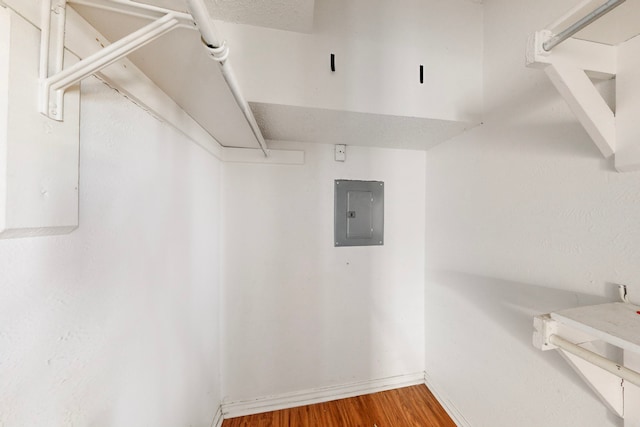 spacious closet featuring electric panel and wood finished floors