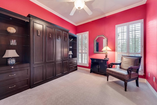 sitting room featuring light carpet, ceiling fan, baseboards, and crown molding