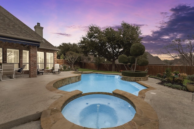 view of swimming pool with a pool with connected hot tub, a patio area, and a fenced backyard