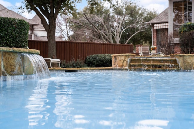 view of swimming pool with fence