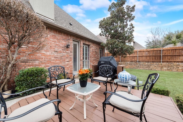 wooden terrace featuring a yard, fence, and grilling area