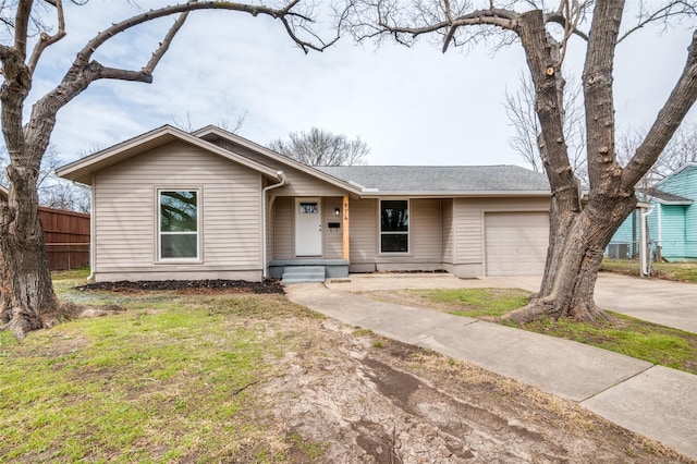 ranch-style home with concrete driveway, an attached garage, and fence