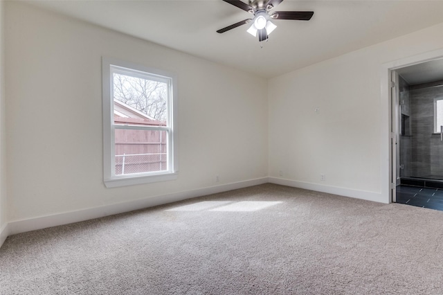 unfurnished room featuring a ceiling fan, dark carpet, and baseboards