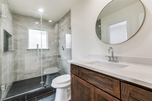 full bath featuring toilet, a stall shower, and vanity