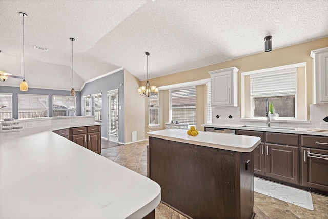 kitchen with visible vents, lofted ceiling, a center island, light countertops, and a sink