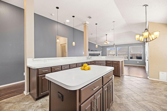 kitchen featuring lofted ceiling, a spacious island, light countertops, and open floor plan