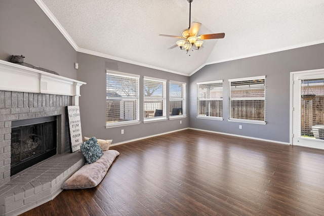 unfurnished living room with ornamental molding, lofted ceiling, a brick fireplace, and wood finished floors