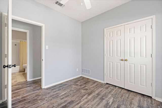 unfurnished bedroom with baseboards, a closet, visible vents, and wood finished floors