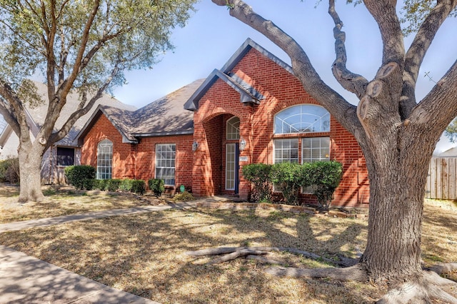 view of front of property with brick siding and fence