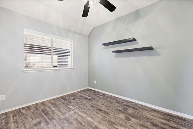 unfurnished room featuring a ceiling fan, vaulted ceiling, a textured ceiling, wood finished floors, and baseboards