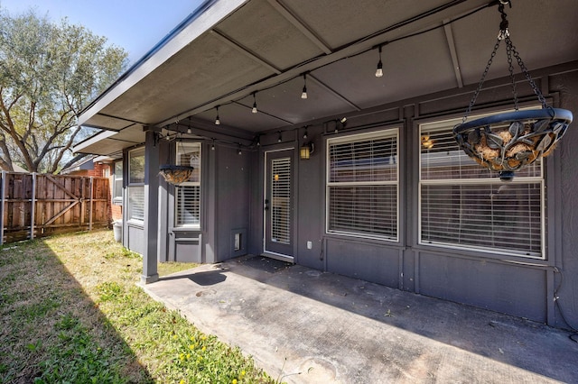 property entrance featuring fence and a patio