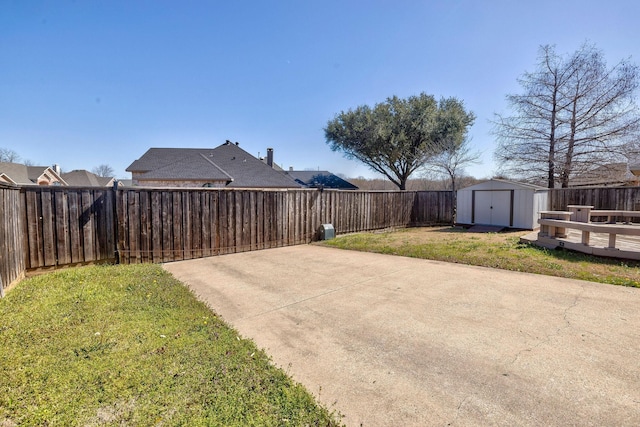 view of yard with an outbuilding, a fenced backyard, a patio, and a storage unit