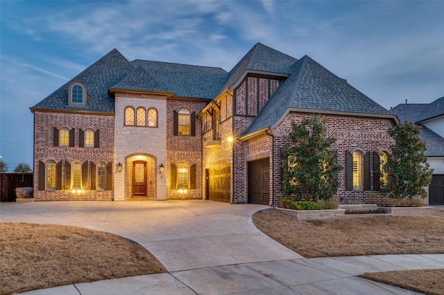 view of front facade featuring driveway, roof with shingles, and brick siding