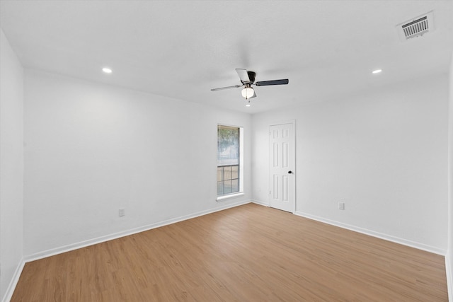 spare room featuring baseboards, visible vents, and light wood-style floors