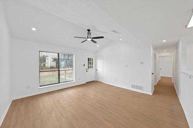 spare room featuring lofted ceiling, visible vents, light wood-style flooring, and baseboards