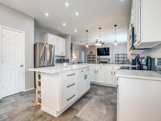 kitchen featuring stainless steel fridge, white cabinets, electric range oven, ceiling fan, and a peninsula