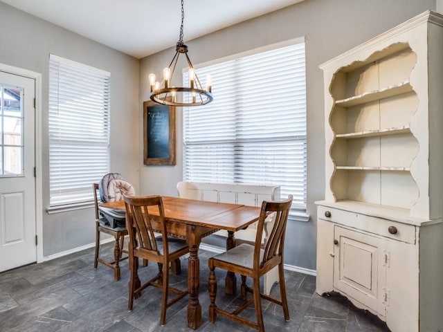 dining area with baseboards and a notable chandelier