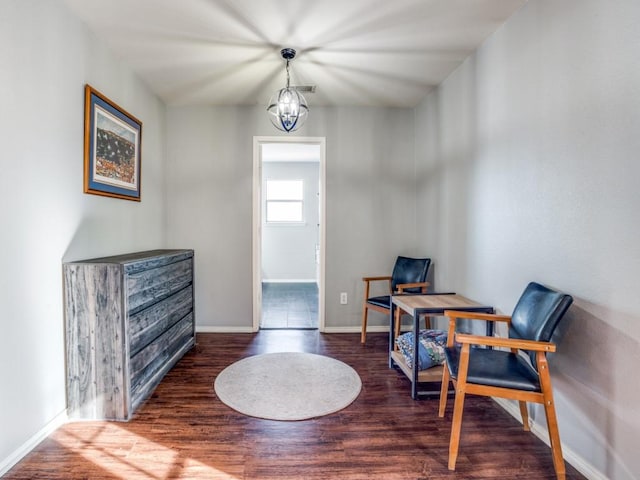 interior space featuring baseboards, wood finished floors, and a notable chandelier