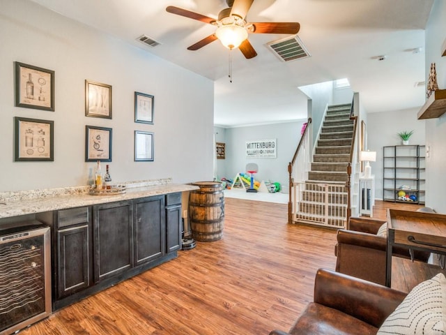 bar featuring a bar, wine cooler, stairway, and visible vents