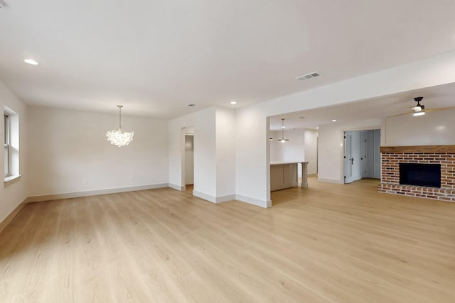 unfurnished living room featuring light wood finished floors, a fireplace, and visible vents