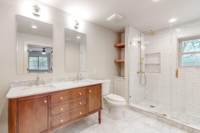 bathroom featuring double vanity, a sink, toilet, and a shower stall