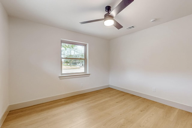 spare room with light wood finished floors, baseboards, and visible vents