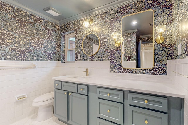 full bathroom with tile walls, toilet, ornamental molding, wainscoting, and wallpapered walls