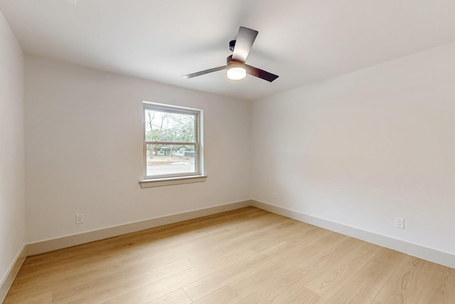 spare room with light wood-type flooring, ceiling fan, and baseboards