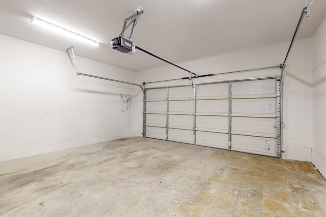 garage featuring a garage door opener and baseboards