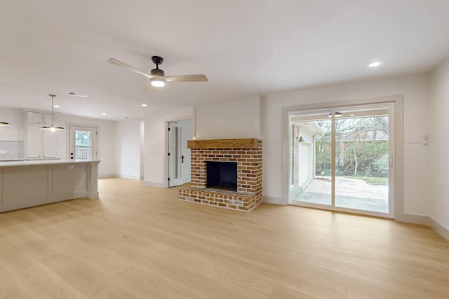 unfurnished living room featuring a fireplace, recessed lighting, light wood-style floors, a ceiling fan, and baseboards