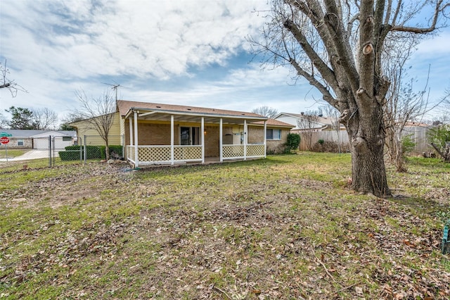 rear view of house with brick siding, a lawn, a fenced backyard, and a sunroom