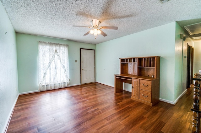 unfurnished office featuring ceiling fan, dark wood-style flooring, a textured ceiling, and baseboards