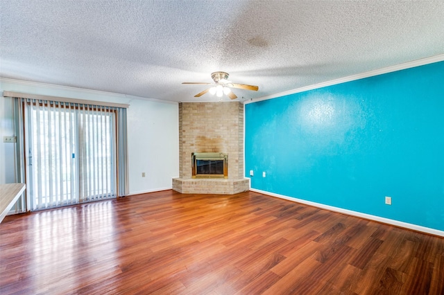 unfurnished living room featuring a fireplace, crown molding, baseboards, and wood finished floors