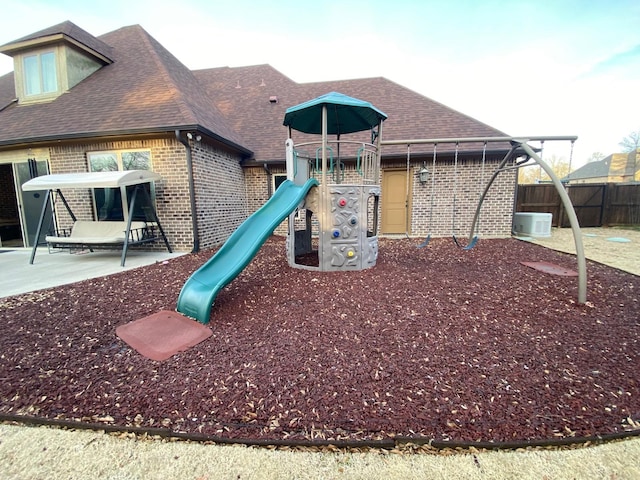 community jungle gym with cooling unit, fence, and a patio