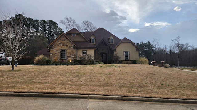 view of front facade with stone siding, a front lawn, and stucco siding