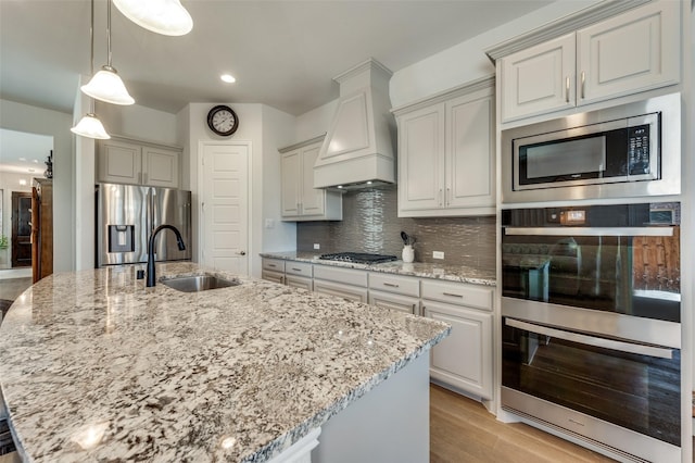 1612 Olympia Ave, Corinth, TX 76208 - kitchen featuring light stone countertops, premium range hood, decorative backsplash, stainless steel appliances, and a sink