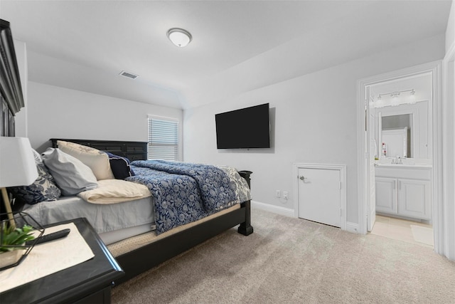 bedroom with baseboards, connected bathroom, visible vents, and carpet flooring