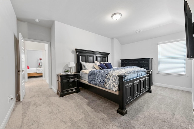 bedroom featuring lofted ceiling, baseboards, and light colored carpet