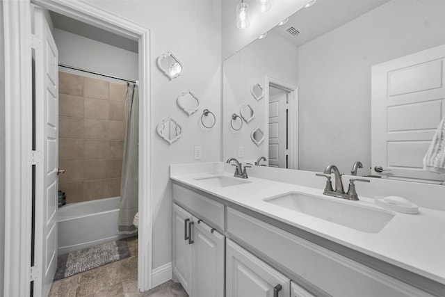 bathroom featuring shower / bath combo with shower curtain, a sink, baseboards, and double vanity