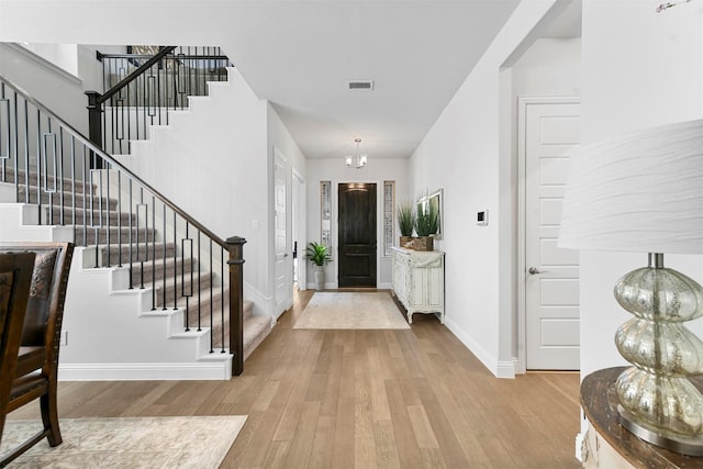 entryway with visible vents, stairs, baseboards, and wood finished floors