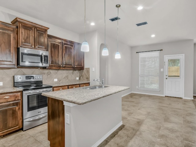 kitchen featuring a sink, visible vents, appliances with stainless steel finishes, backsplash, and decorative light fixtures