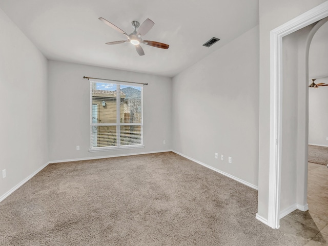 empty room featuring ceiling fan, carpet, and visible vents