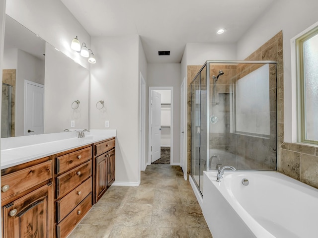 full bath with a bath, vanity, a shower stall, and visible vents